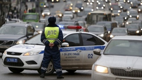 A traffic police officer stands guard as vehicles drive past in central Moscow, Russia, December 5, 2015. REUTERS/Sergei Karpukhin - RTX1XABI